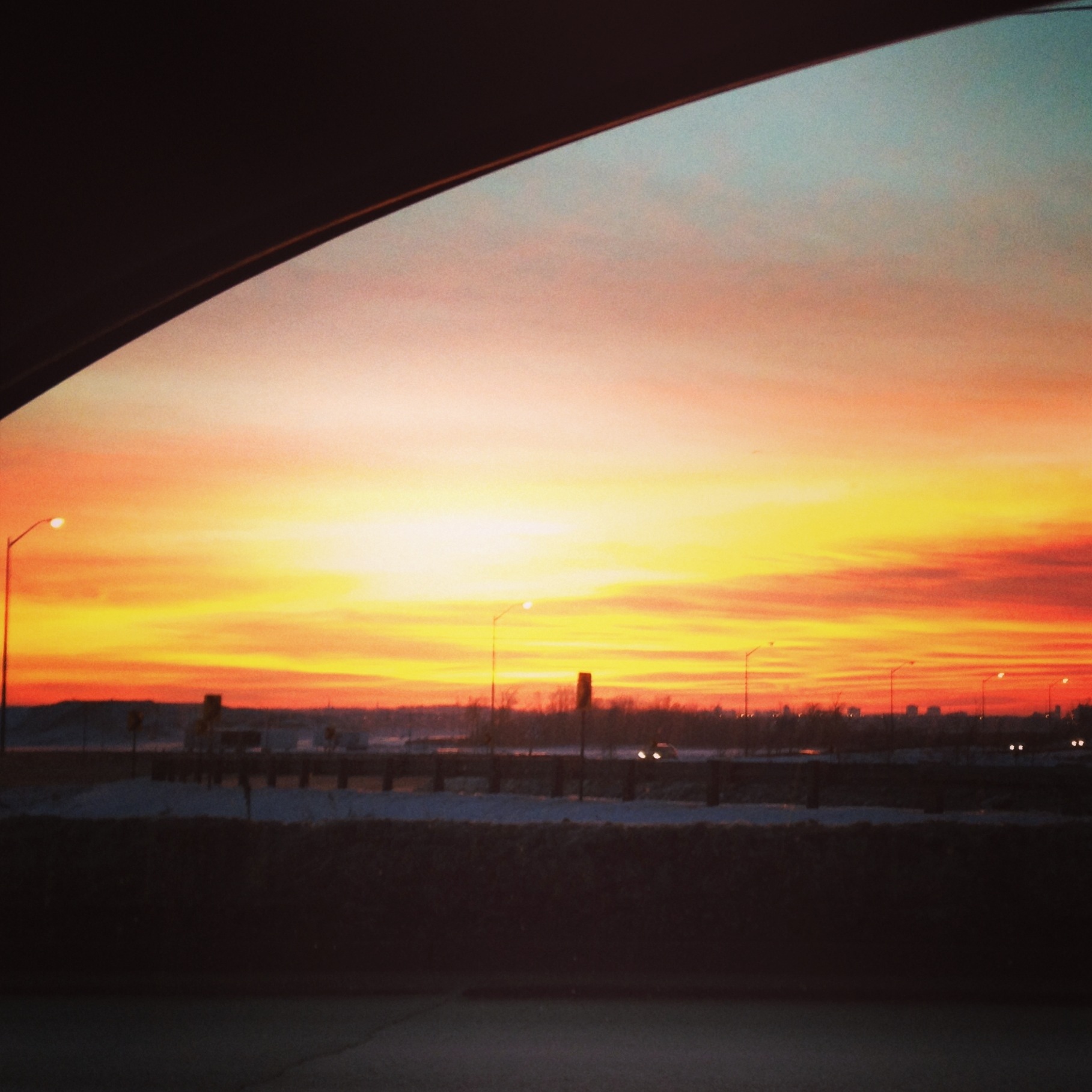 Sunrise through curved window with trees in distance